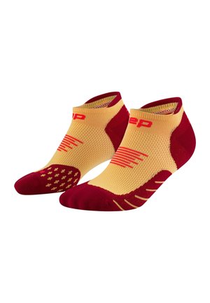 Low-cut athletic socks featuring a yellow body with maroon accents, textured grips, and patterned knit for enhanced comfort and fit.