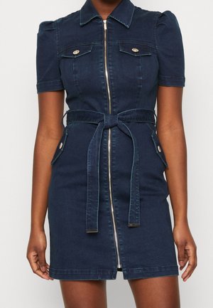 Jeanskleid mit Reißverschluss vorne, kurzen Puffärmeln, zwei Brusttaschen, einem Stoffgürtel und kontrastierenden Nähten in dunkler Waschung.