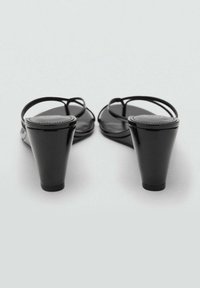 Sandalias de charol negro con tiras delgadas y un tacón cónico, que cuentan con una superficie suave y un diseño de punta redonda.