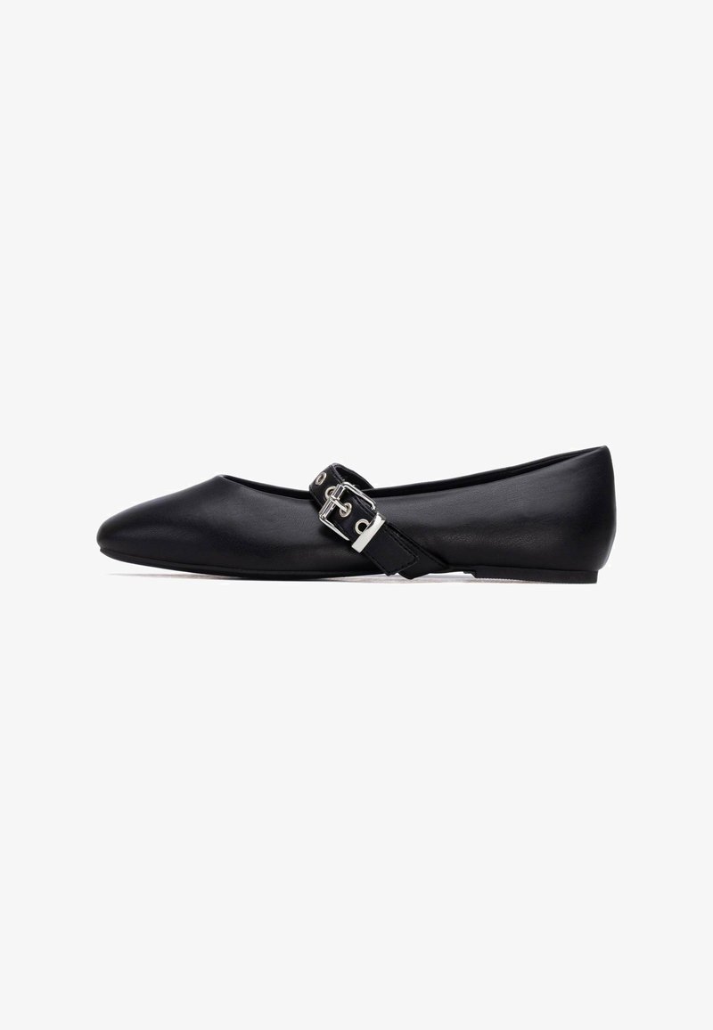 Bailarinas de cuero negro con punta puntiaguda, con una correa con hebilla plateada y diseño minimalista. Textura suave, perfil bajo.