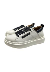 Sneakers bianchi in pelle con accenti blu navy, suola bianca spessa, lacci piatti blu navy e un'etichetta logo visibile sul lato. Texture liscia, design minimale.