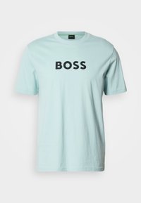 Hele sinine puuvillane t-särk ümarate kaelaräämaste ja lühikeste varrukatega. Rinnal on paksu musta kirjatüübiga sõna „BOSS”.