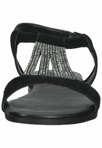 Black suede sandal with a flat sole, featuring a decorative silver rhinestone fringe. Strappy design with an open toe and adjustable ankle strap.