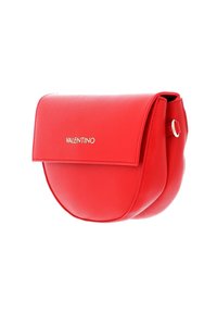 Červená kožená crossbody taška s zaobleným tvarem, plochým víkem a zlatými doplňky. Má detail v podobě smyčky na boku.