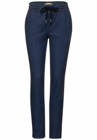 Námořnické modré tapered joggers s texturovaným vzorem, elastickým pasem a černým límcem. Materiál vypadá hladce a mírně leskle.