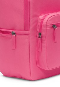 Ροζ ύφασμα σακίδιο πλάτης με υφή, που διαθέτει δύο τσέπες με φερμουάρ στην μπροστινή και πλευρική όψη. Ορατές ανθεκτικές ραφές και λεπτομέρειες από υλικό.