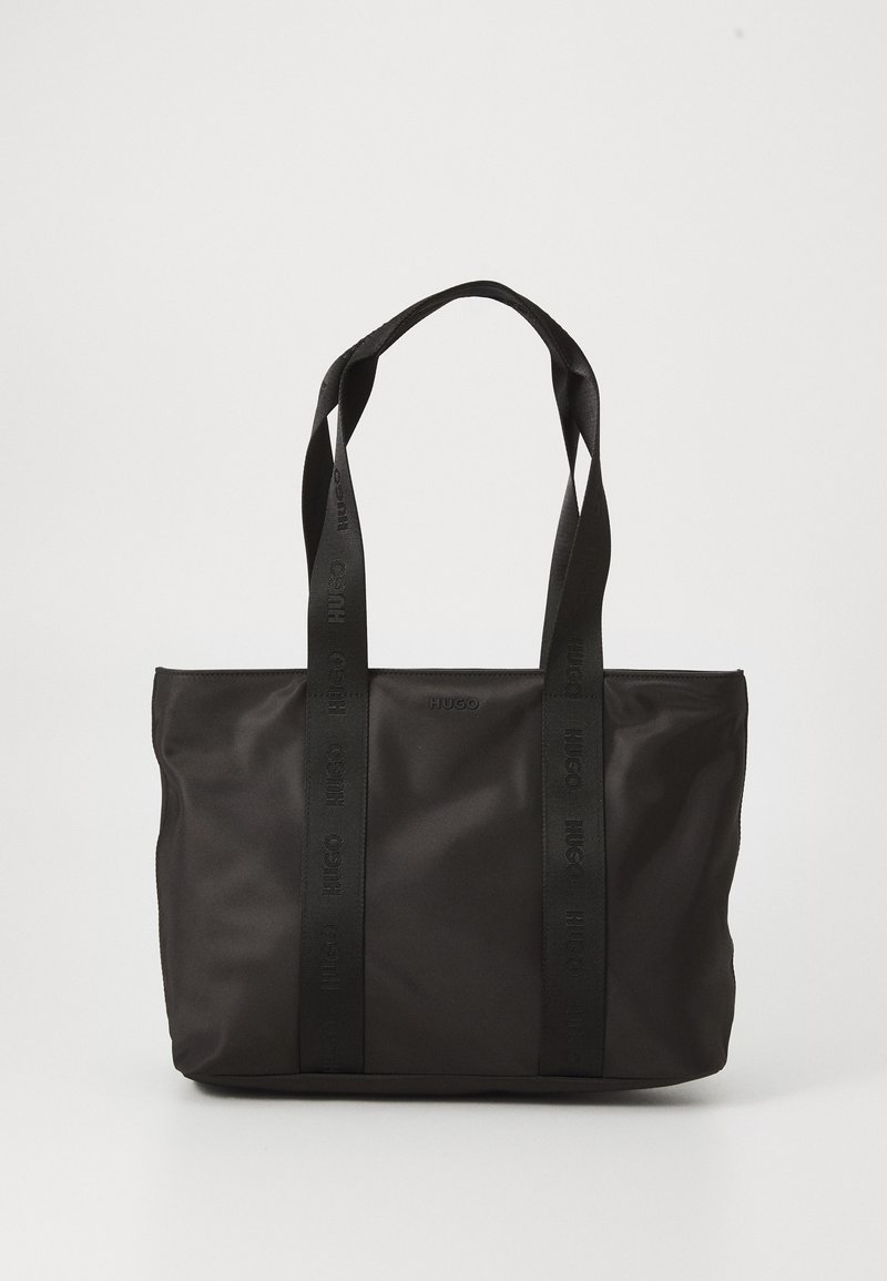 Sac fourre-tout noir en nylon avec deux poignées solides, présentant une surface texturée et un logo en relief. Design simple sans embellissements supplémentaires.