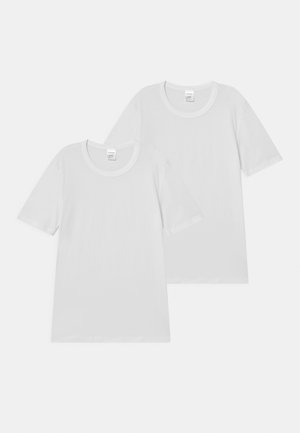 Due t-shirt bianche semplici con maniche corte, colli rotondi e una texture di cotone morbido, impilate leggermente sovrapposte.