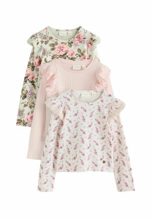 Three long-sleeve girl’s tops with floral patterns and ruffled lace details in pink, light pink ribbed, and white with small flowers.