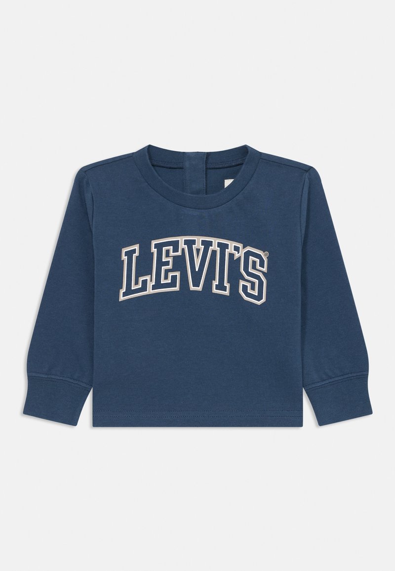 Pitkähihaine sininen T-paita, joka on valmistettu puuvillasta ja jossa on kaareva valkoinen "LEVI'S" -logo rintamuksessa sekä pyöreä kaula-aukko.