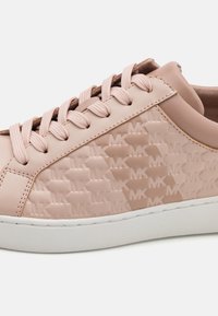 Sneaker rosa chiaro in pelle liscia con lato testurizzato caratterizzato da un motivo logo in rilievo. Suola in gomma bianca e lacci coordinati.