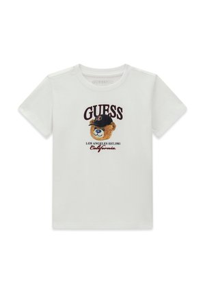 T-shirt blanc à manches courtes avec un ours en peluche portant une casquette noire, texte ""GUESS"" en haut, et ""Los Angeles Est. 1981 California"" en bas.