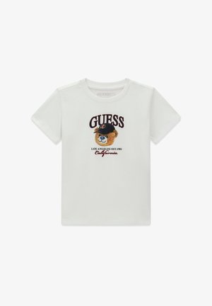 T-shirt blanc à manches courtes avec un ours en peluche portant une casquette noire, texte ""GUESS"" en haut, et ""Los Angeles Est. 1981 California"" en bas.