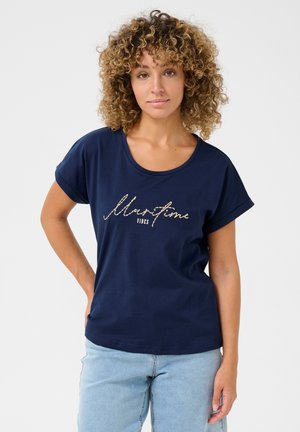 T-shirt bleu marine en coton, avec un col en scoop, des manches courtes roulées et un design en texte pailleté doré qui dit "Vibes Maritimes."