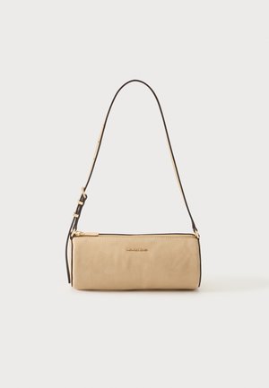 Sac d'épaule cylindrique en cuir beige avec une bandoulière noire ajustable et une fermeture éclair dorée, avec le logo Michael Kors au centre avant.