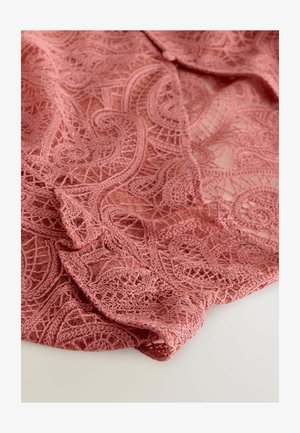 Tela de encaje rosa con intrincados patrones en espiral y bordados detallados. La textura es ligera y semi-translúcida.