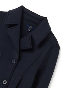 Abrigo infantil en azul marino, confeccionado en tejido suave, con un cuello clásico, cierre de botones doble y bolsillos laterales.