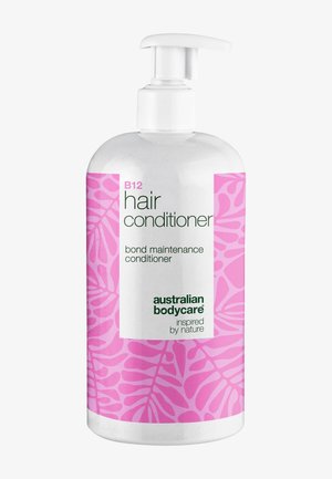 Pullo Australian Bodycare B12 -hiustenhoitoainetta, jossa on vaaleanpunainen lehtikuvioinen etiketti ja valkoinen pumppupullo.