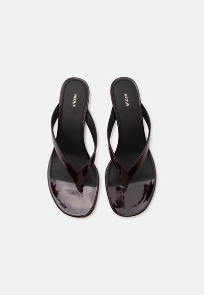 Pair of black patent leather thong sandals with square toes and the brand name NEOUS on the footbeds, shown from above.