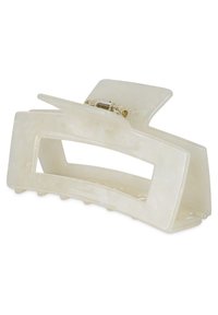 Fermaglio per capelli a artiglio realizzato in plastica traslucida di un leggero color beige, con un design ondulato, dotato di una molla in metallo dorato e denti di grip.