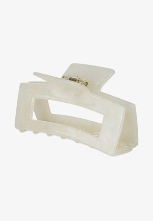 Clip de pelo tipo garra hecho de plástico translúcido en un tono beige claro con un diseño ondulado, que cuenta con un resorte y dientes de agarre en metal dorado.