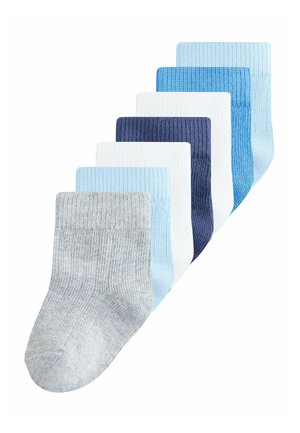 Sept paires de chaussettes bébé côtelées en gris, bleu clair, blanc, bleu marine et bleu moyen, disposées en éventail sur un fond blanc.
