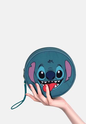 Runde tealfarbene Tasche mit einem Grafiken von einem Cartoon-Charaktergesicht, das große Augen, einen offenen Mund und eine auffällige Zunge hat. Enthält einen Handgurt.