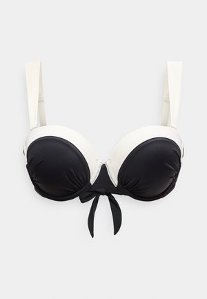 Schwarz-weißer, gepolsterter BH mit verstellbaren weißen Trägern und schwarzer Schleife in der Mitte vorne.