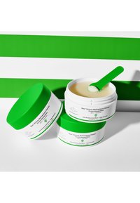 Makeup-schmelzender Butter Reiniger in Gläsern mit weißem und lebhaft grünem Design, runder Form und grünem Löffel. Etikett mit Produktdetails in Weiß.