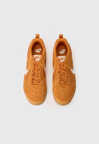 Nike sneakers oranzhi sametist, mille on tekstuuriga ülemine osa, valged logo aktsendid ja kummitald. Kujundatud pehme krae ja paeltega.