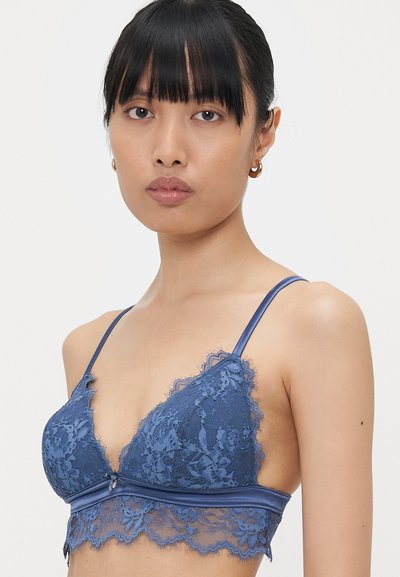Blue lace bralette featuring triangular cups, scalloped edges, satin straps, and a decorative front bow detail. Soft, delicate texture.