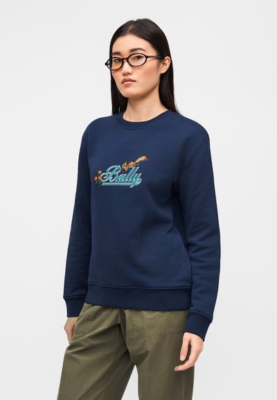 Μπλε ναυτικό φούτερ με κεντημένο λογότυπο "Bally", με υφασματικές λεπτομέρειες και στρογγυλή λαιμόκοψη. Συνδυάζεται με παντελόνι σε ελιά πράσινο χρώμα.