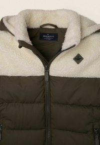 Padded černá bunda v tmavě olivové barvě s bílým fleecovým límcem. Obsahuje přední zip a diamantovou logo cedulku na hrudi. Měkká textura.