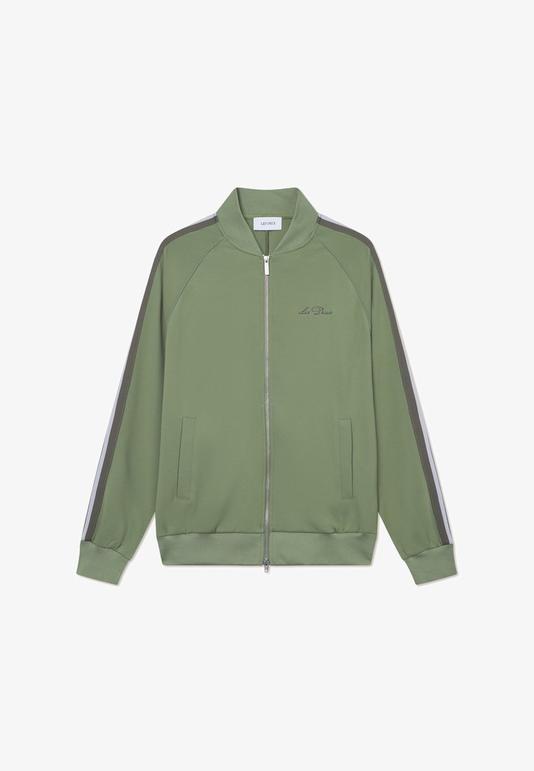 Zaļš sporta jaka ar rāvējslēdzēju, augstu apkakli, sānu kabatām un kontrastējošām svītrām uz piedurknēm. Gluda auduma ar izšūtu logo detaļu.