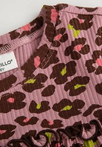 Brązowy wzór w panterę na teksturowanej różowej tkaninie, z falbaniastym dołem i ciemnoniebieską dekoltem. Metka widoczna w pobliżu kołnierza.