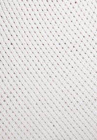 Tela de punto blanca con un patrón texturizado diagonal, que presenta pequeñas manchas de un color más oscuro, creando un sutil interés visual.