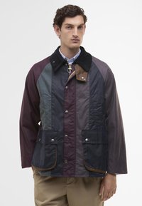 Férfi, többszínű dzseki, kordbársony gallérral, patent gombokkal és nagy zsebekkel. Simább, tartós anyagból készült, változatos árnyalatokban.