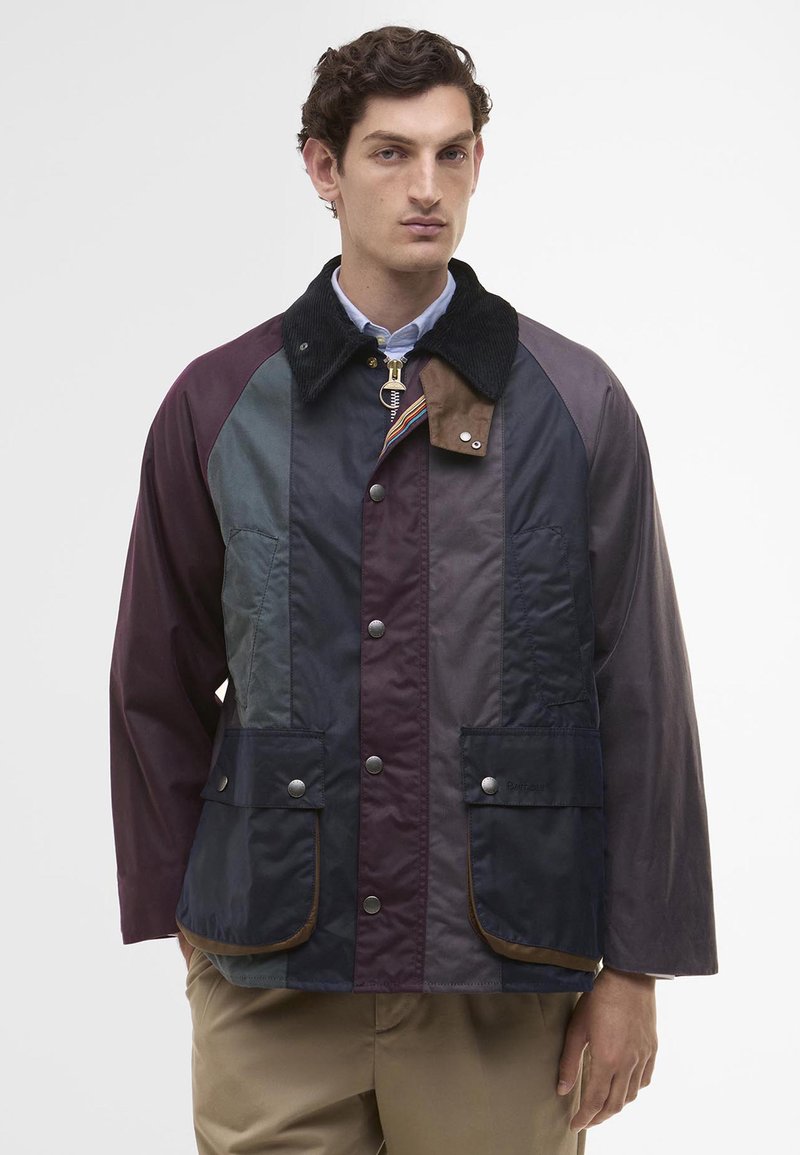 Férfi, többszínű dzseki, kordbársony gallérral, patent gombokkal és nagy zsebekkel. Simább, tartós anyagból készült, változatos árnyalatokban.