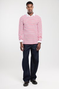 Rødt og hvidt stribet langærmet skjorte med hvid krave, parret med mørkeblå jeans og sorte sko. Pasform er afslappet.