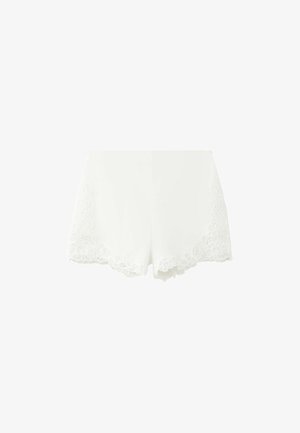 Witte damesshorts met geschulpte kanten rand langs de zoom aan beide pijpen, weergegeven tegen een effen witte achtergrond.