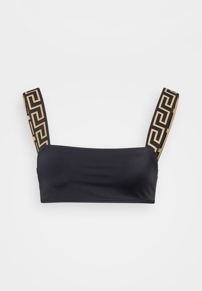 Juodas bandeau tipo viršus iš lygaus audinio, su plačiomis petnešėlėmis, puoštomis geometriniu auksiniu raštu. Paprastas, be siūlių dizainas.