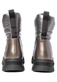 Bottines argentées métalliques avec un design rembourré, dotées d'une semelle texturée noire contrastante et d'une languette pour un enfilage facile.