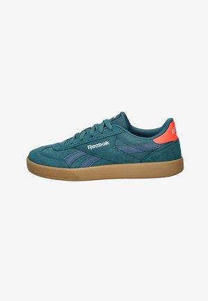 Teal suède lage sneaker met gumzool, marineblauwe zijstrepen, teal veters en oranje hieltab met witte Reebok-bedrukking.