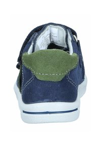 Navy suede sneaker with green accents at the heel, white rubber sole, and hook-and-loop closure. Interior label visible.
