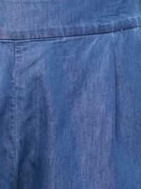Tissu en denim bleu avec une couture visible et une texture subtile, montrant une ceinture cousue et une partie d'un vêtement plissé.