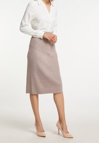 Weißes Hemd mit Kragen und langen Ärmeln, kombiniert mit einem knielangen, strukturierten, hellbraunen Bleistiftrock und hautfarbenen High Heels.