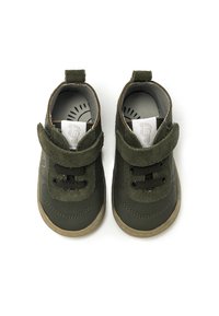 Zapatos infantiles de cuero y ante verdes con puntera redonda, correa de velcro y cordones negros. Cuentan con una suela de goma texturizada.