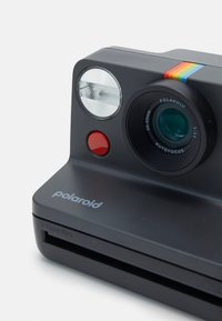 Polaroid camera in matte black with a round lens, red shutter button, flash, and a colorful horizontal stripe design on top.