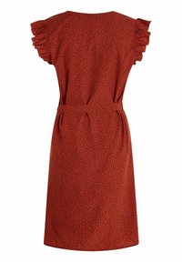 Röd klänning med korta volangärmar, midja med bälte och ett mönster av små svarta prickar på ett texturerat tyg. Knälång klipp.