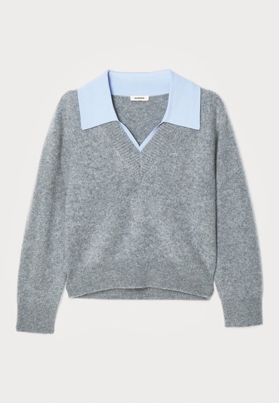 Grå strikkegenser med lyseblå krageinnsats, V-halsdesign, lange ermer og ribbestrikket kant, med en myk tekstur.